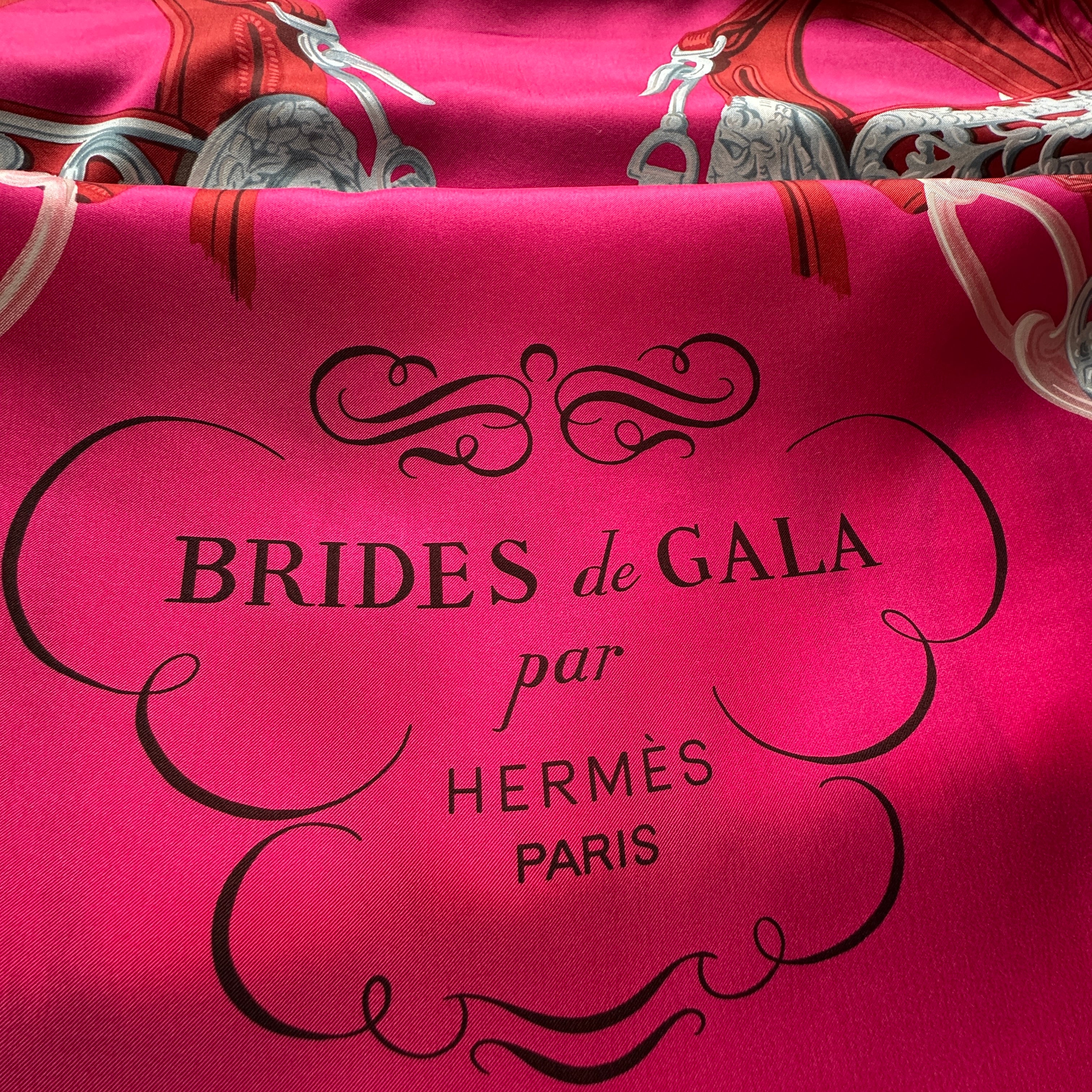Détail des mors et rênes équestres sur le châle Brides de Gala Hermès, couleur fuchsia