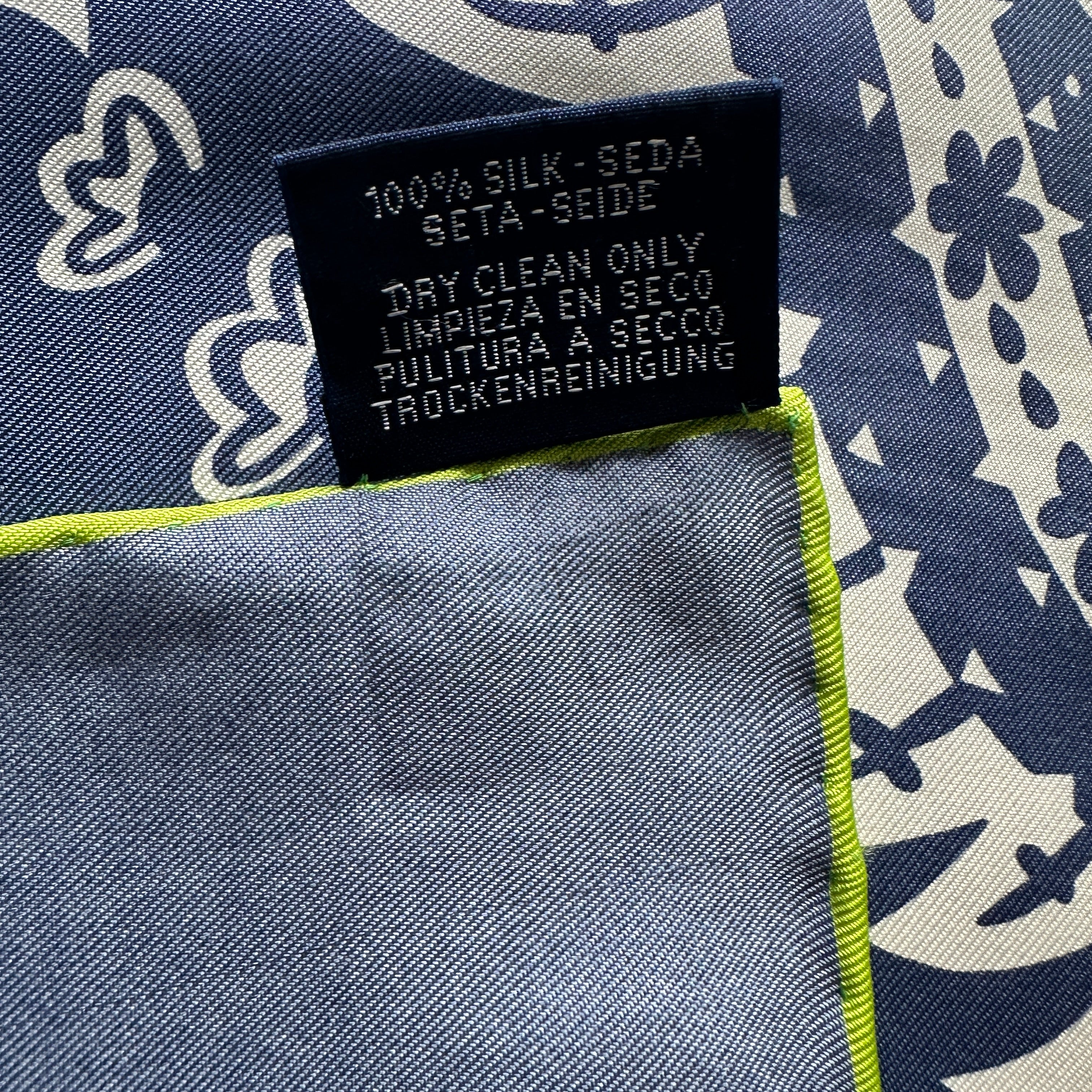 Verso de l'étiquette d'entretien du foulard Hermès, avec les mentions "100% SILK - SEDA - SETA - SEIDE" et "DRY CLEAN ONLY" en plusieurs langues.