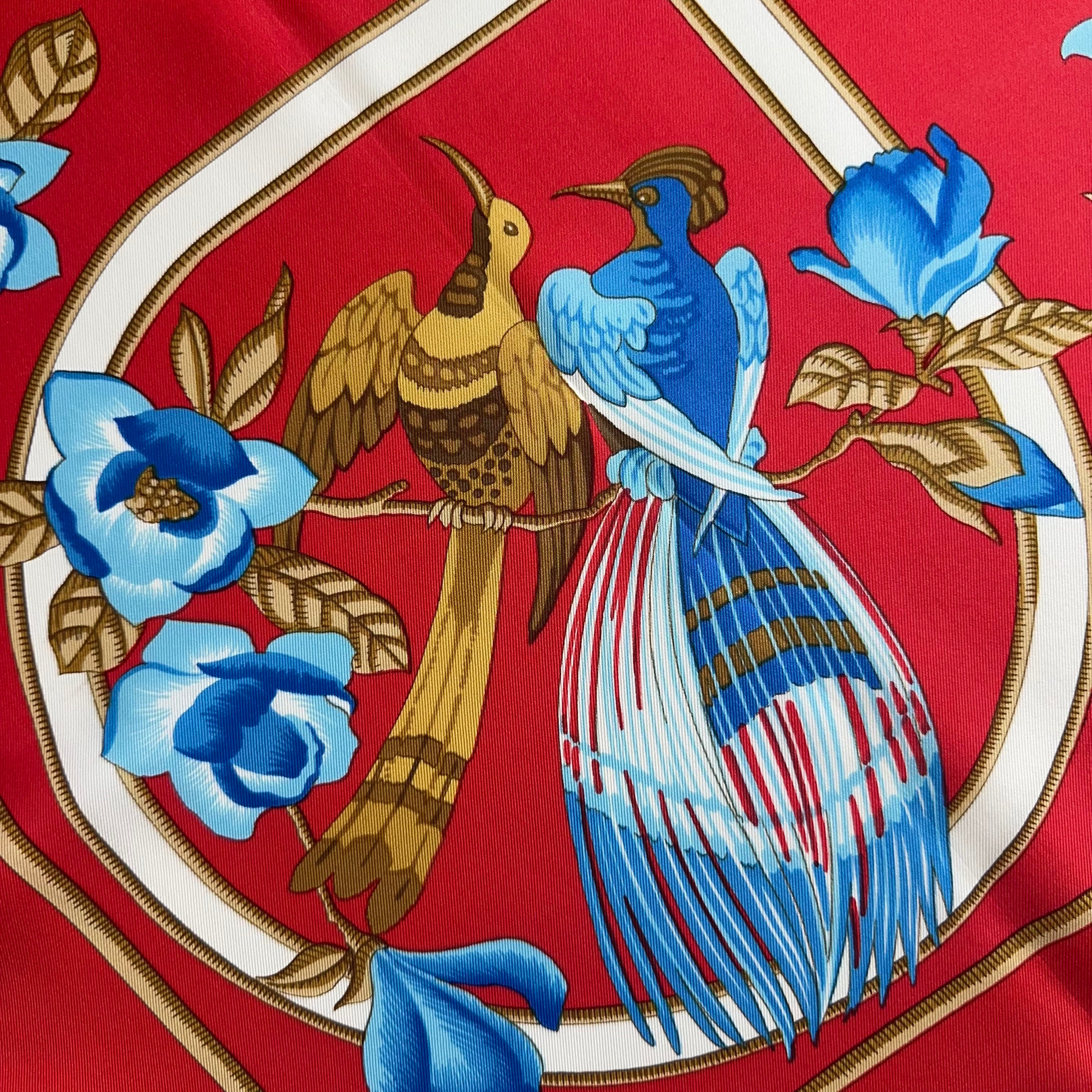 Médaillon latéral montrant un couple d'oiseaux tropicaux, l'un or, l'autre bleu azur, perchés au milieu de fleurs bleues.