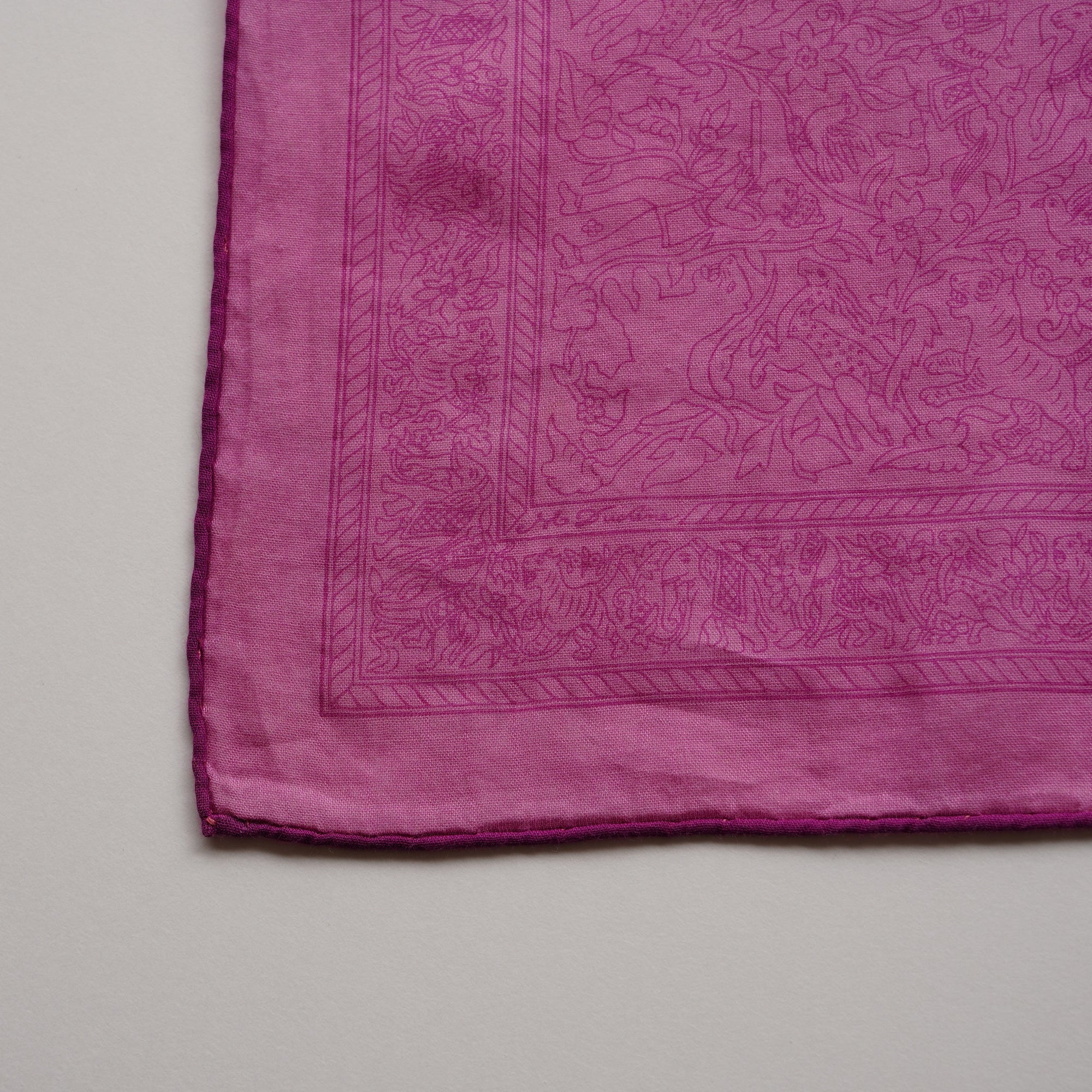 Vue rapprochée sur la bordure du carré Hermès collector "Chasses Indiennes" en coton rose