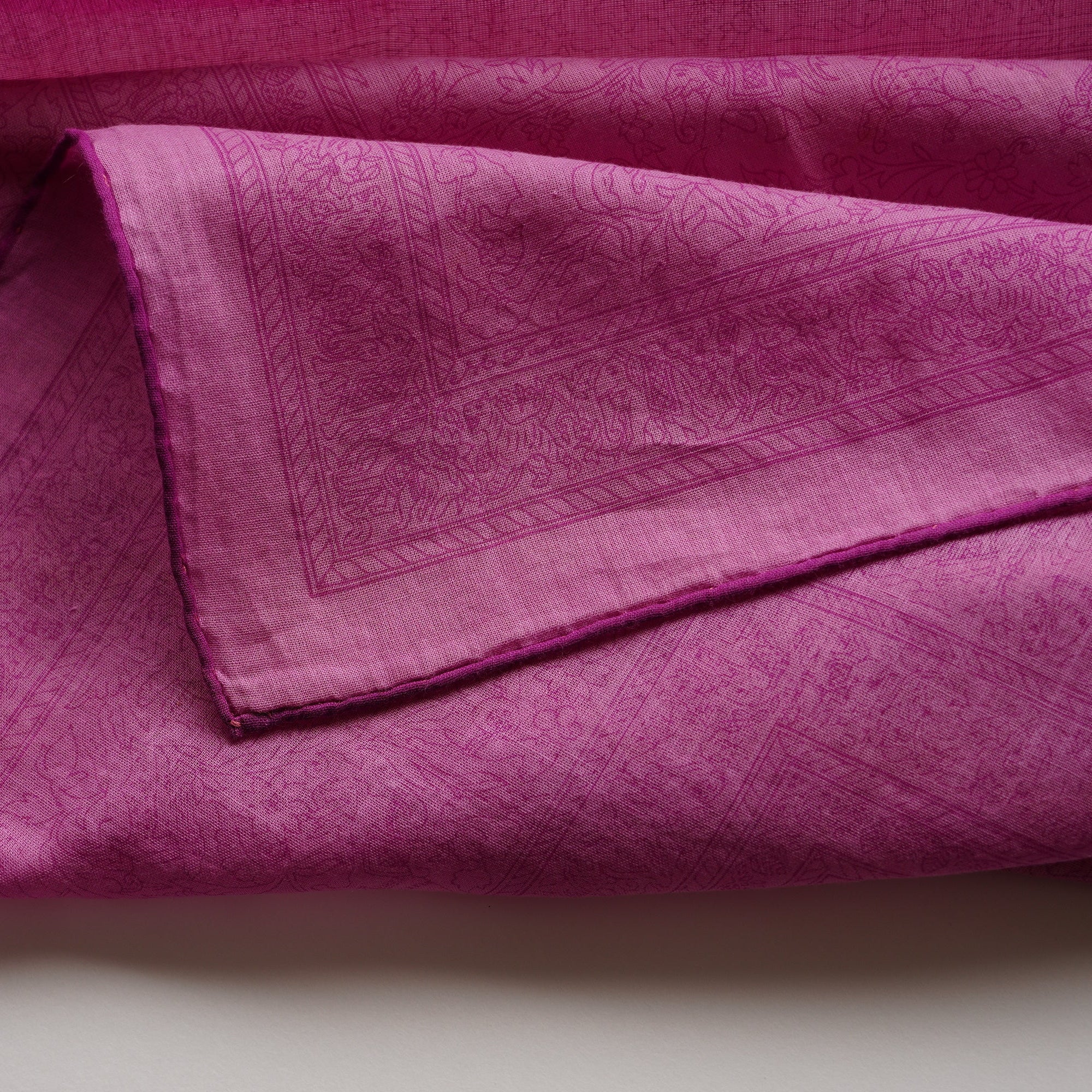 Gros plan sur l'angle du foulard Hermès "Chasses Indiennes", mettant en valeur le voile de coton.