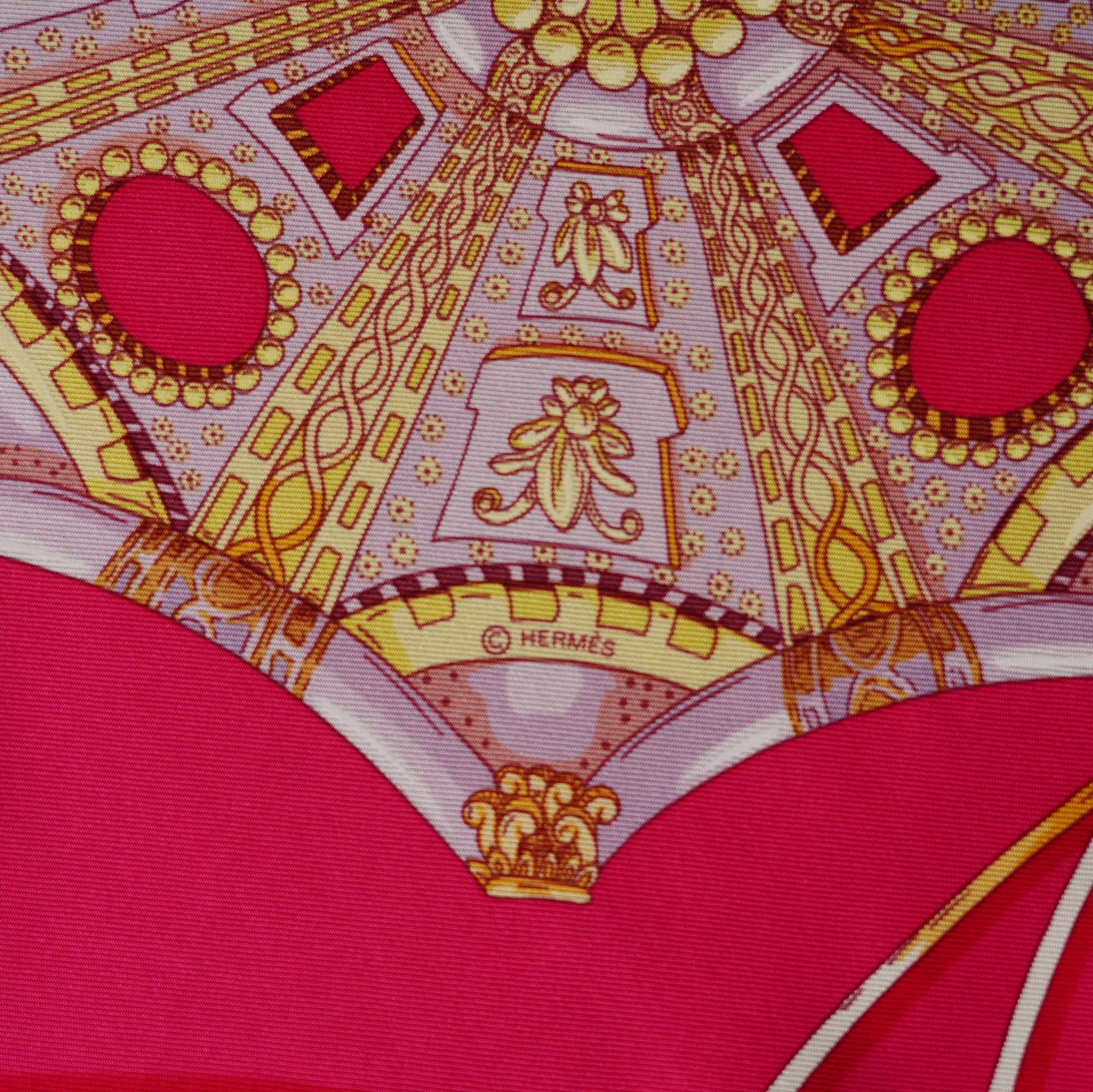 Détail très rapproché sur la complexité géométrique d'une coupole centrale or et blanche, chef-d'œuvre de précision sur fond rose avec le logo de copyright Hermès dans le dessin