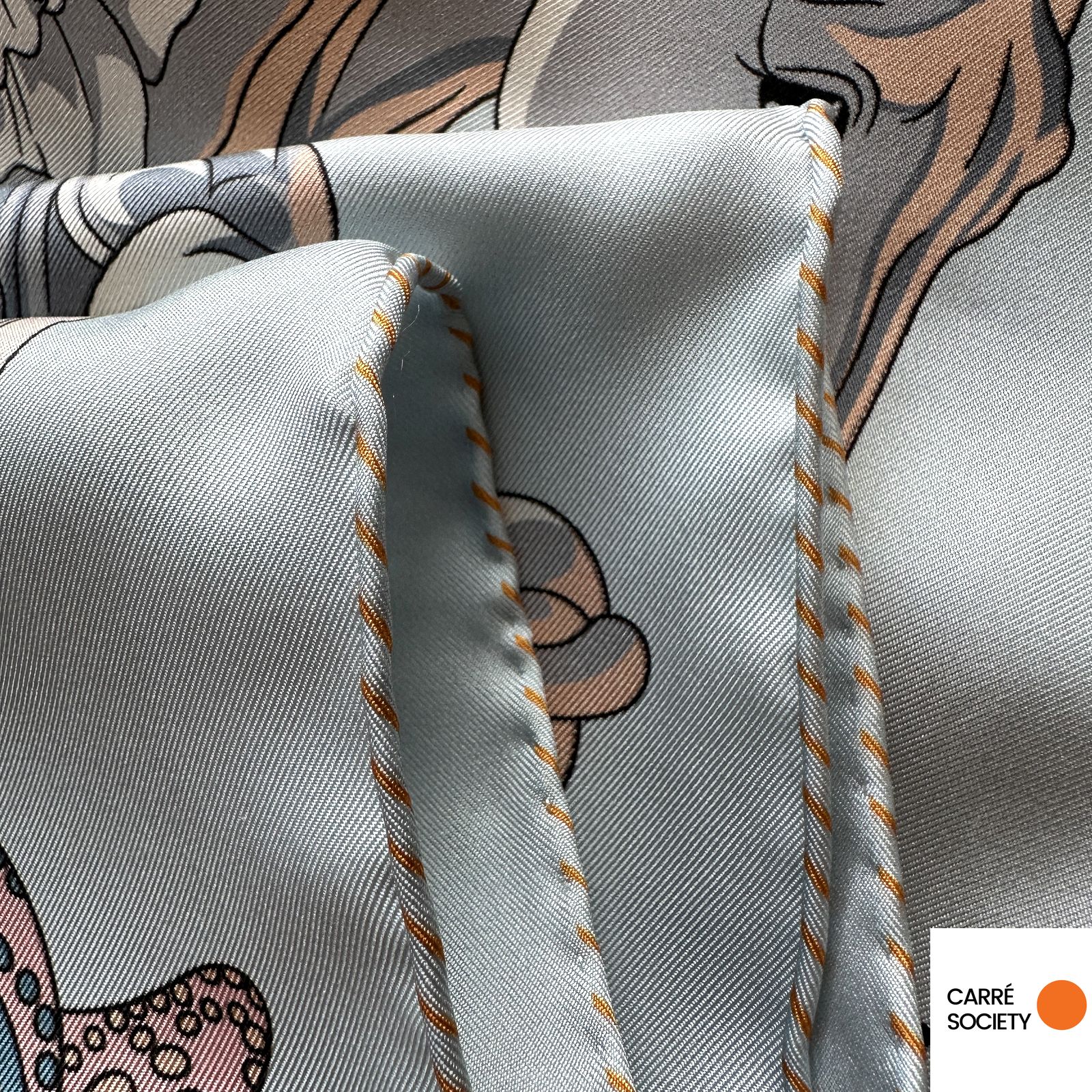 Vue rapprochée du roulotté à la main – foulard Hermès bleu clair