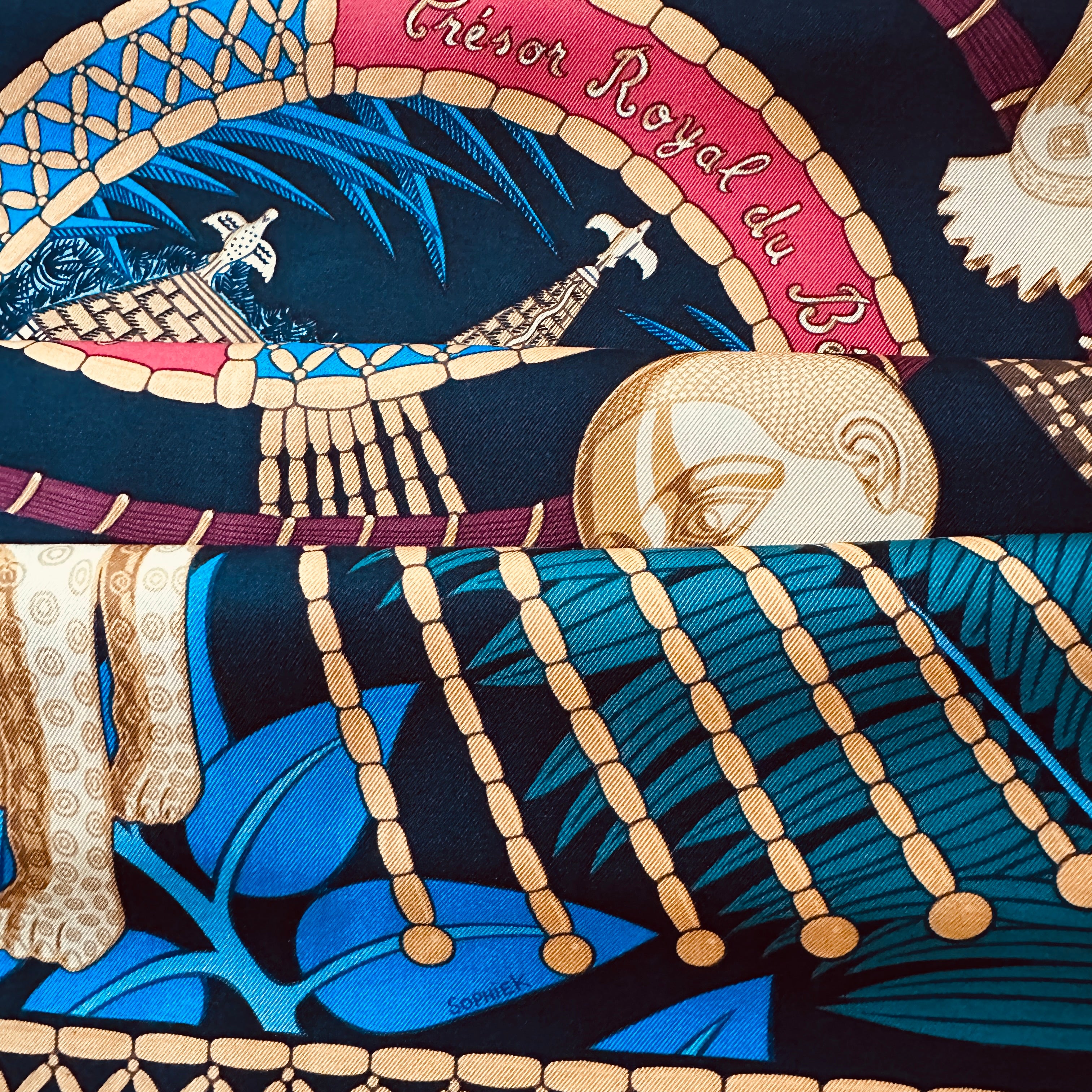 Gros plan sur le roulotté main et les couleurs vibrantes du revers de la soie. Signature du designer "Sophie K" (Sophie Koechlin) dans le dessin