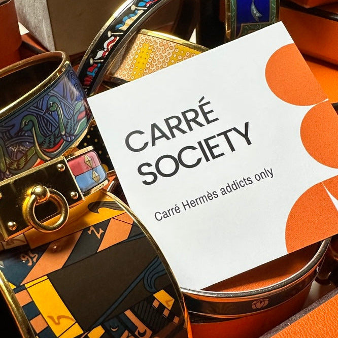 carte de visite carré society au milieu d'une collection de bijoux Hermès vintage