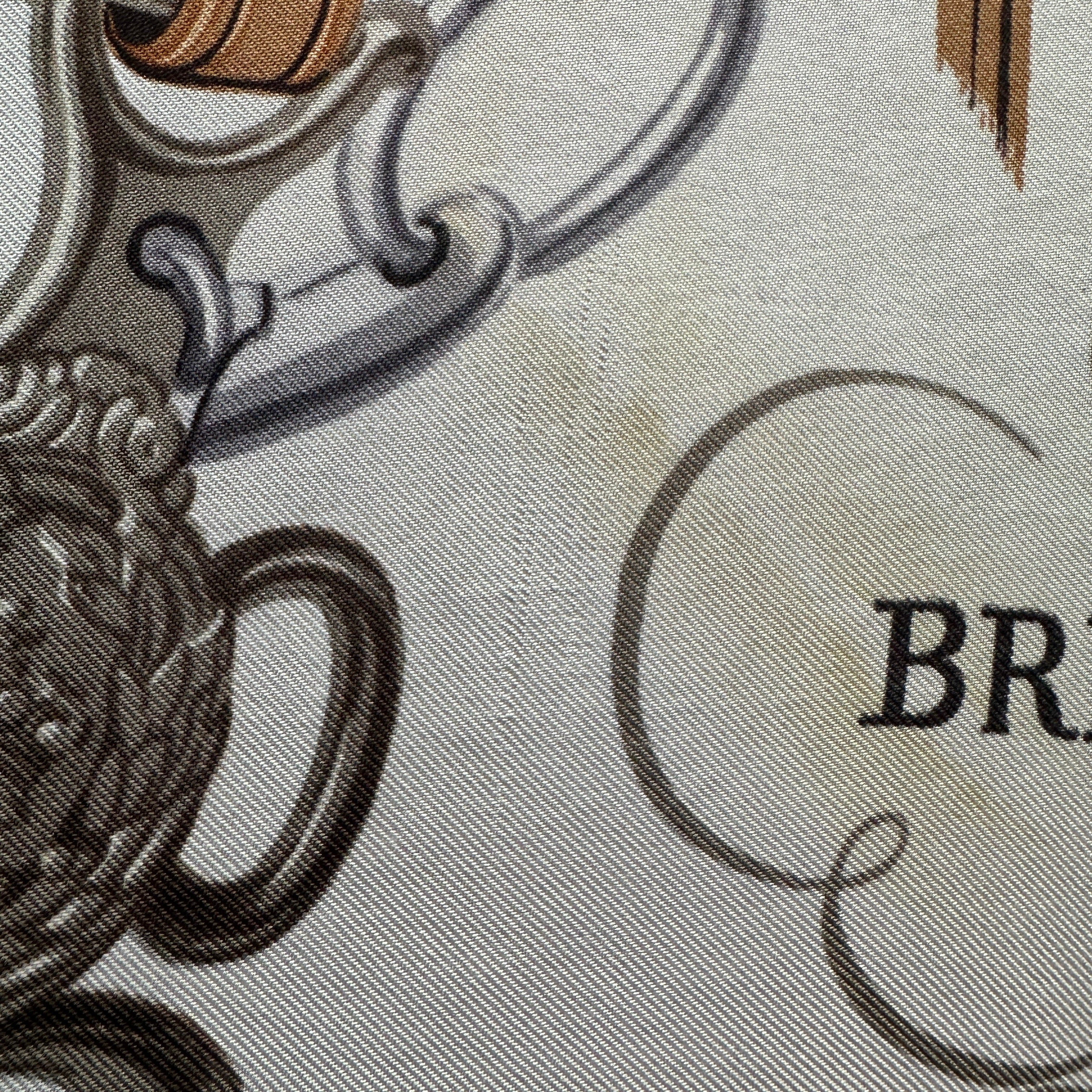 transparence sur l'état du foulard vintage : zoom sur une tâche et des fils tirés dans la soie 