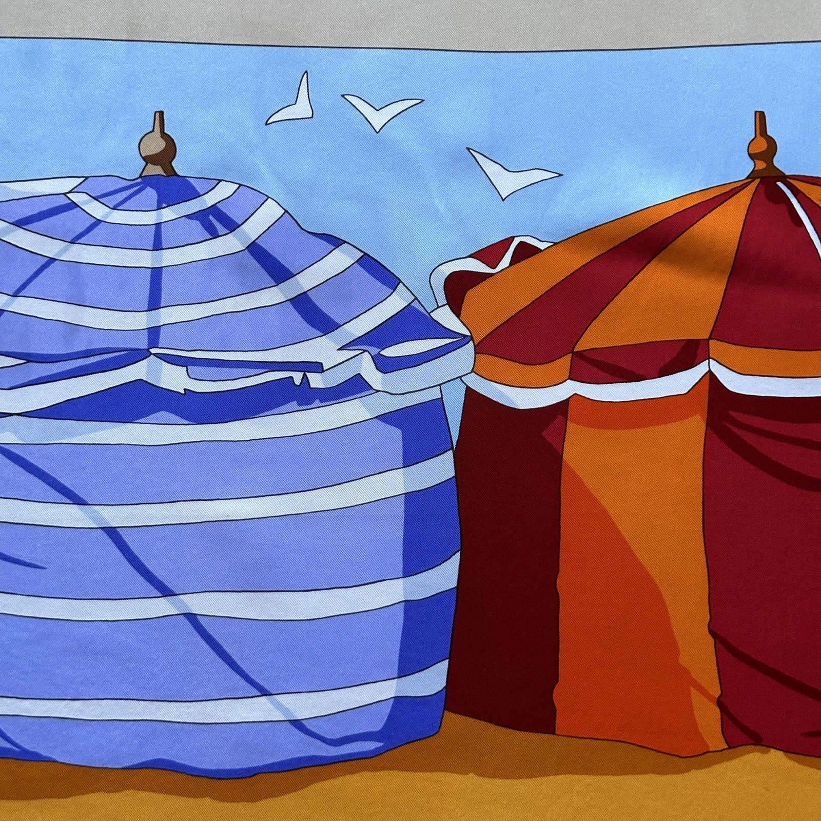 Détail des tentes de plage bleue et orange sur fond de mer et mouettes